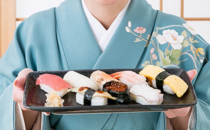 寿司を持つ女性の画像